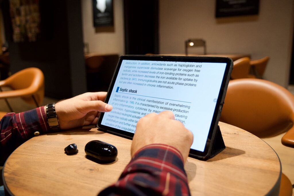 タブレットで記事を読んでいる人物の手元
