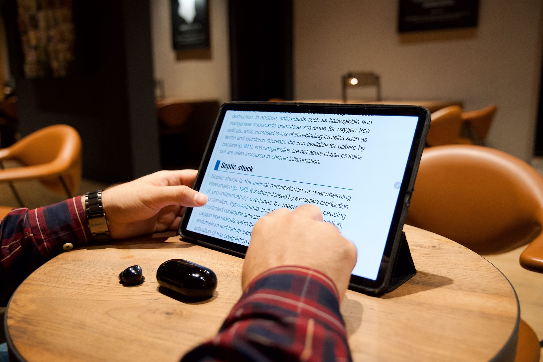 タブレットで記事を読んでいる人物の手元