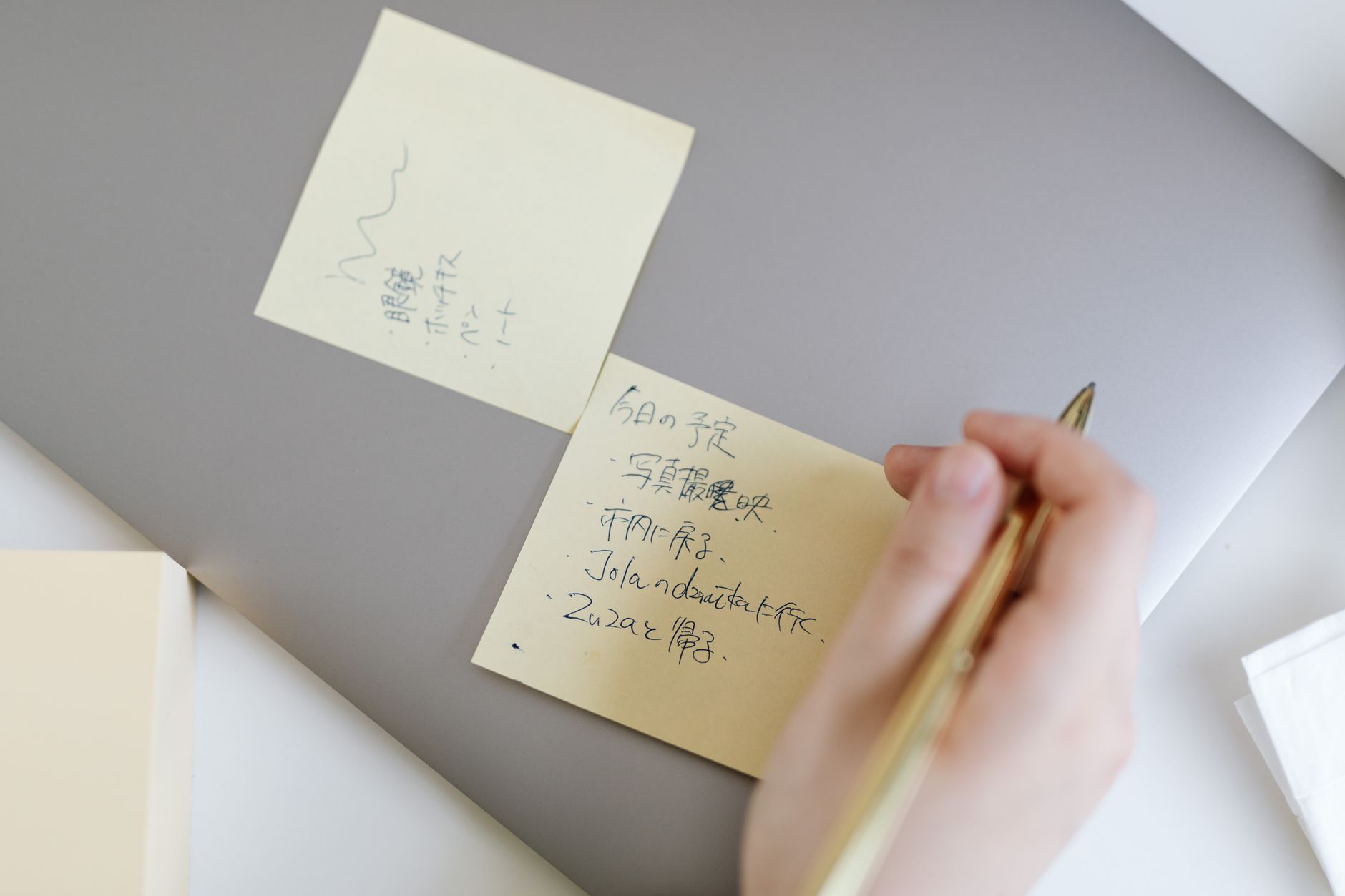 ノートパソコンの前でメモを取りながら記事構成を考える様子