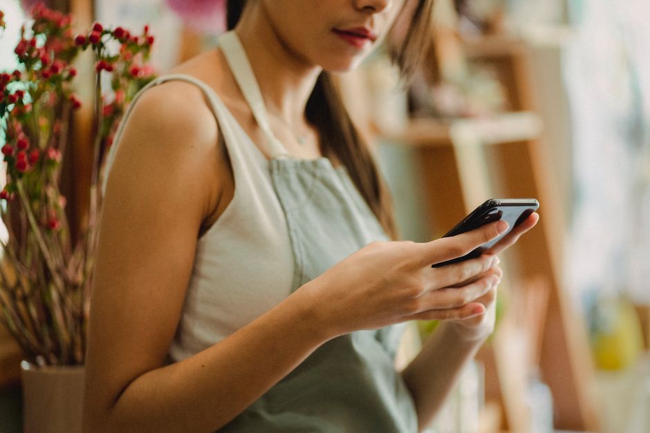 店舗のオーナーがスマートフォンで情報を確認している様子
