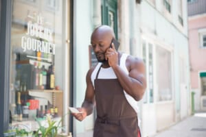 個人店の店主がスマートフォンで地図アプリを確認している様子