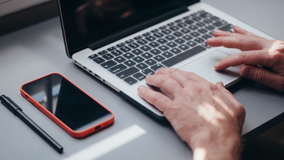 ノートパソコンでSNS投稿を作成する中小企業の担当者